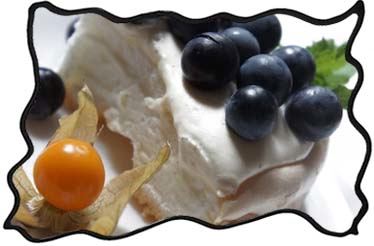 Slice of Pavlova cake with grapes and physalis